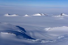 04D Small Mountains Pop Up From The Surrounding Glacier From Airplane Flying From Union Glacier Camp To Mount Vinson Base Camp.jpg